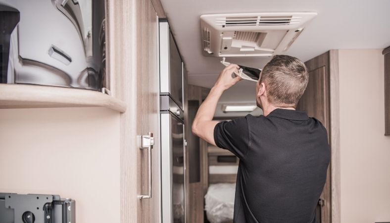 A man doing a routine maintenance in his static caravan